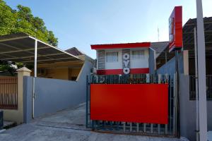a red gate in front of a house at SUPER OYO 710 Naomi Heritage in Surabaya