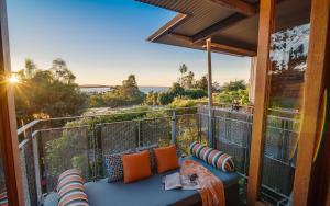 a balcony with a blue couch on a deck with the view at Noosa Residences in Noosa Heads