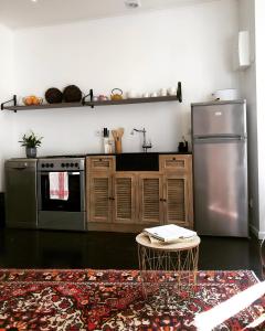 een keuken met een roestvrijstalen koelkast en een tafel bij Studio du Cherche Midi in Jarnac