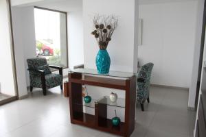 a vase of flowers on a table with two chairs at Condominio Paseo Vista Mar in Lima