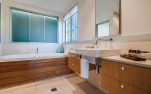 a bathroom with a sink, bathtub and a window at Noosa Residences in Noosa Heads