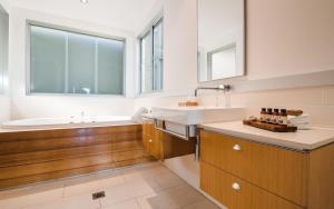 a bathroom with a sink and a bath tub at Noosa Residences in Noosa Heads