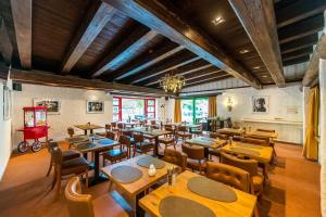 CONTEL Hotel في كوبلنز: مطعم فارغ بطاولات وكراسي خشبية