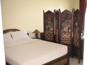 a bedroom with a bed with white sheets and wooden headboards at residence papillon in Thong Son Beach