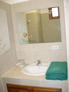 a bathroom sink with a mirror and a green towel at residence papillon in Thong Son Beach