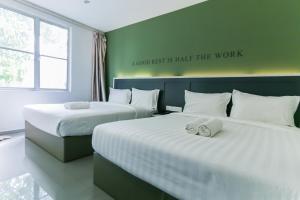 two beds in a room with a sign on the wall at Hotel 99 Kota Kemuning in Shah Alam