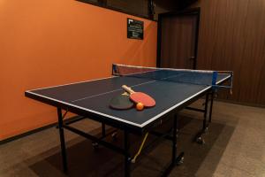 una mesa de ping pong con dos raquetas de tenis. en HOTEL Mai Sakura, en Nara
