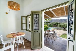 a dining room with a table and chairs and a door at Aeolus pool apts in Palekastron