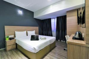 a hotel room with a bed with a laptop on it at Hotel 99 SS2 Petaling Jaya in Petaling Jaya