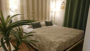 a bedroom with a bed with green curtains and a plant at Il Giglio Verde in Porto SantʼElpidio