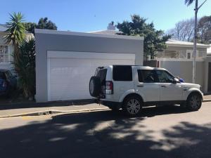 a white suv parked in front of a garage at At 27 on Derby in Cape Town