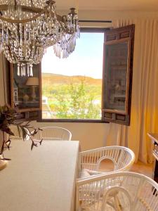 comedor con lámpara de araña, mesa y sillas en La Casa del Jabonero, en Cuevas Bajas