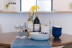 uma mesa com garrafas de vinho e copos de vinho em Villa Mahalo ＜1日１組限定＞ em Yomitan