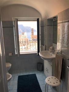 baño con lavabo y ventana en Villa La Mura, en Atrani