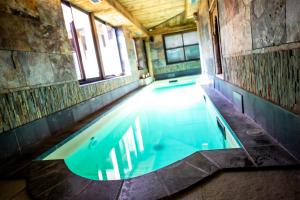 蓬莱韦克金狮温泉酒店的一座室内游泳池,位于一座带窗户的建筑中