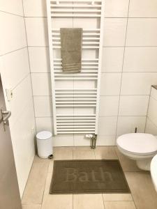 a bathroom with a toilet and a bathmat on the floor at Ferienwohnung Asal in Waldbronn