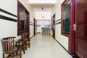a corridor with chairs and a table in a room at RedDoorz Syariah @ Ketintang Surabaya in Surabaya
