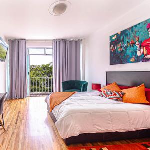 um quarto com uma cama e uma grande janela em Roma Sur Apartments with Balcony - Family Friendly em Cidade do México