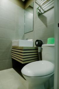 uma casa de banho com um WC branco e um lavatório. em The Horizon Suites and Arcade em General Santos
