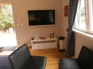 a living room with a flat screen tv on the wall at Stuga på Hasslö in Bredavik