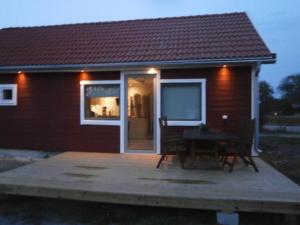 een klein huis met een tafel ervoor bij Stuga på Hasslö in Bredavik