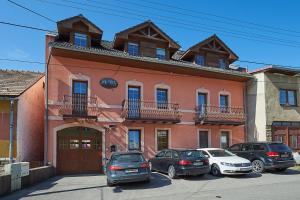 a building with cars parked in front of it at Penzion Mystery in Vyšné Ružbachy