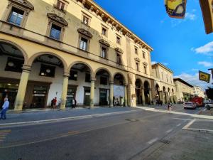un edificio en una calle de la ciudad con gente caminando por la calle en I Portici Hotel - Residenza D'Epoca, en Arezzo