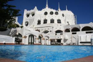 a large white swimming pool with a balcony at Club Hotel Casapueblo in Punta del Este