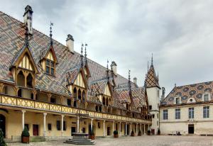 un bâtiment avec un toit en carrelage et une cour dans l'établissement S'House, à Beaune