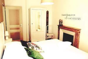 - une chambre avec 2 lits blancs et une cheminée dans l'établissement S'House, à Beaune