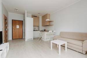 a white living room with a couch and a table at ShortStayPoland Zdziechowskiego (B72) in Warsaw