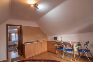 eine Küche mit einem Tisch und Stühlen im Zimmer in der Unterkunft Dobra Haz in Covasna