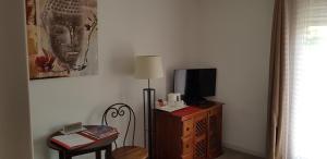サン・ポール・ド・ヴァンスにあるレ バスティード サン ポールのデスク、テレビ、椅子が備わる客室です。