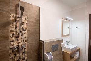ein Bad mit einer Dusche und einem Waschbecken in der Unterkunft Guesthouse Stari Mayr in Kranj