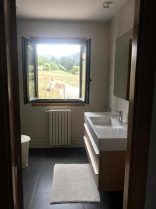 La salle de bains est pourvue d'un lavabo et d'un cheval à l'extérieur de la fenêtre. dans l'établissement Casa de Campo, à Potes