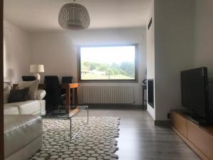 een woonkamer met een bank en een televisie bij Casa de Campo in Potes