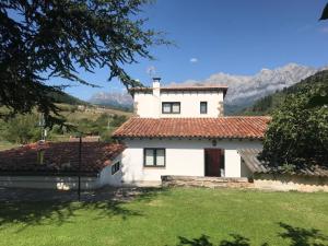 een wit huis met een rood dak bij Casa de Campo in Potes