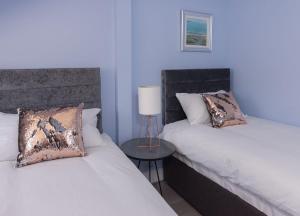 a hotel room with two beds and two lamps at Titanic Boutique, Luxury 4 Star Guest House in Belfast