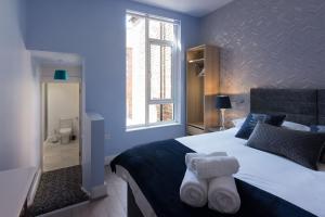 um quarto com uma cama grande e toalhas em Titanic Guest Boutique, 4-Star Accommodation em Belfast