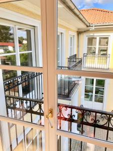 a door to a balcony with a view of a building at Villa am Steinhuder Meer App Suite-La Fleur-mit Pantry Küche, Luftreinigungssystem, Garten, WLAN in Steinhude