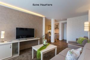 een woonkamer met een bank en een tv bij Kurmittelhaus Wagner in Willingen
