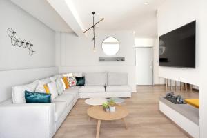 a white living room with a white couch and a table at Urban Melodies Apartment in Athens