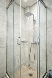 a shower with a glass door in a bathroom at Urban Melodies Apartment in Athens