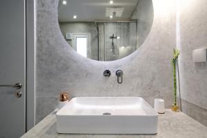 a bathroom with a white sink and a mirror at Urban Melodies Apartment in Athens +42 photos