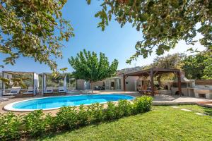 a backyard with a swimming pool and a pavilion at Villa4Dreams in Gerani