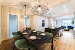 a dining room and living room with a table and chairs at GRAN VIA SUITE APARTMENT in San Sebastián