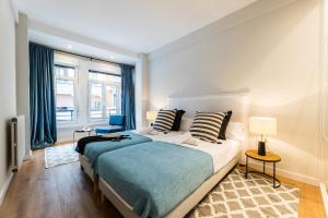 Un dormitorio con una cama grande y una ventana. en GRAN VIA by SWEET HOME SAN SEBASTIAN, en San Sebastián