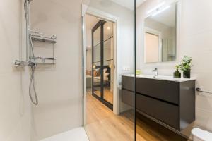 un baño con lavabo y espejo en GRAN VIA by SWEET HOME SAN SEBASTIAN, en San Sebastián 28 fotos más