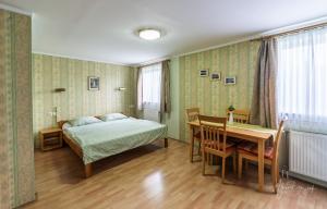 a bedroom with a bed and a desk and a table at Panorama B&B in Ptuj