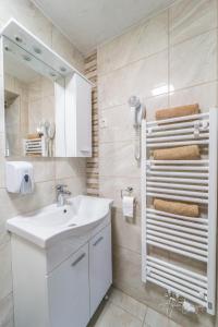 a white bathroom with a sink and a mirror at Panorama B&B in Ptuj